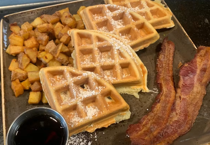 picture of waffles, potatoes, and bacon on a plate